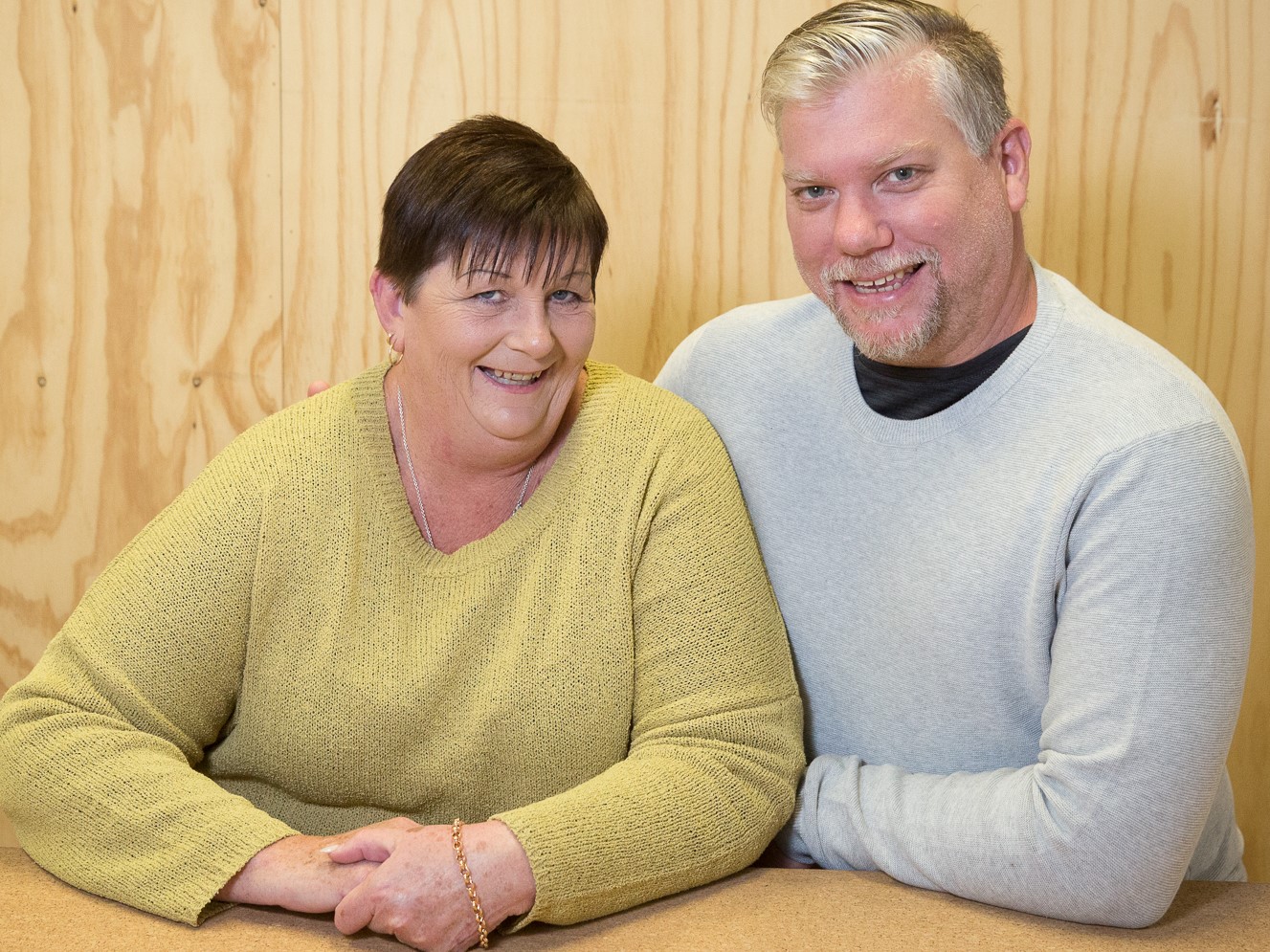 Junction carers, Nathan and Michelle. 2 carers Michelle and Nathan sitting at a table and smiling at the camera